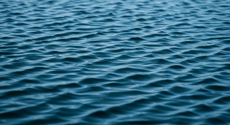 Blue water surface texture background. Close up of ripples in sea water.の素材