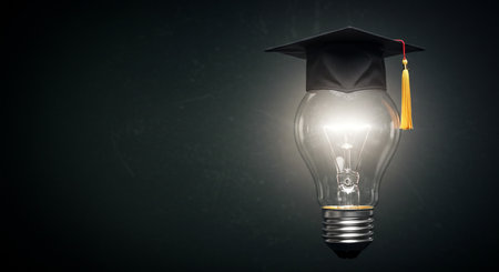 Glass lightbulb with graduation cap and diploma on blackboard backgroundの素材