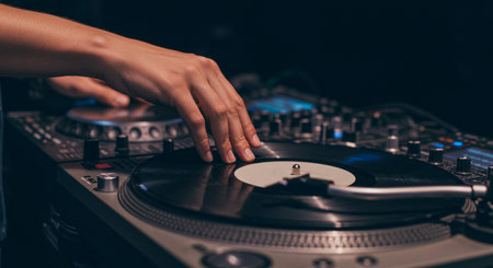 Close-up of dj playing music on turntable in nightclubの素材