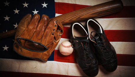 A group of vintage baseball equipment, bats, gloves, baseballs American flag backgroundの写真素材
