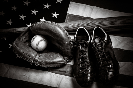 A group of vintage baseball equipment, bats, gloves, baseballs American flag backgroundの写真素材