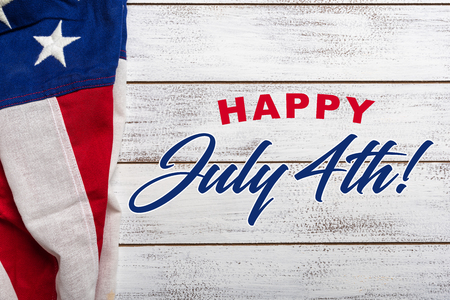 United states flag on white, weathered clapboard background with july 4th greetingの写真素材
