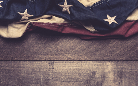 A vintage American flag or bunting on a wooden background with copy spacaeの写真素材