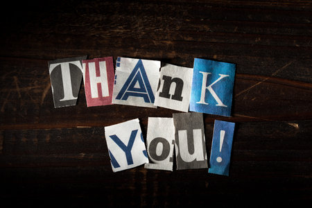 The message -thank you- with cut out letters from newspapers etc. on black backgroundの写真素材