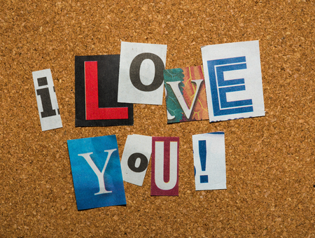The message -I Love You- with cutout letters on a brown corkboardの写真素材