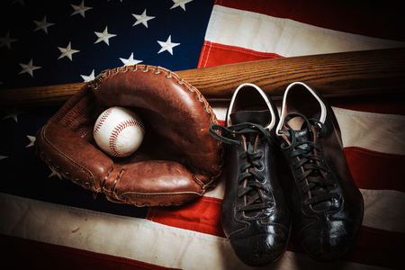 A group of vintage baseball equipment, bats, gloves, baseballs American flag backgroundの写真素材