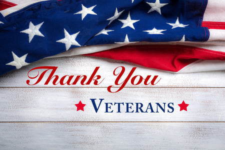 United states flag on white, weathered clapboard background with Veterans Day greetingの写真素材