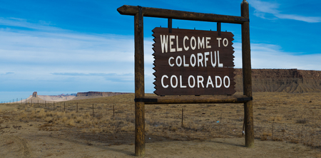 Welcome to Colorado sign wiht blue sky and mountains in the backgroundの写真素材