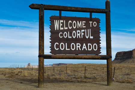 Welcome to Colorado sign wiht blue sky and mountains in the backgroundの写真素材