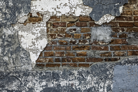 A rustic dilapidated brick wall background with plaster and concreteの写真素材