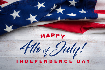 United states flag on white, weathered clapboard background with july 4th greetingの写真素材