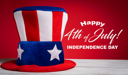 A felt colorful Uncle Sam hat on red background with Happy July 4th greetingの写真素材