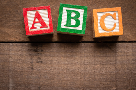 Multi-colored wooden letter blocks on natura wood backgroundの写真素材