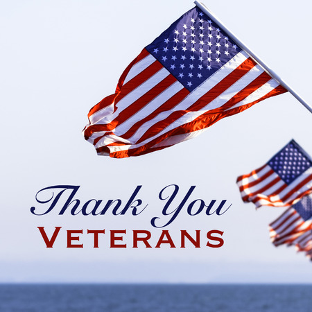 American flags with a Veterans Day greeting with blue sky baacakgroundの写真素材