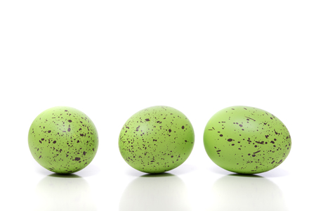 A group of green Easter Eggs with speckles on a white backgroundの写真素材