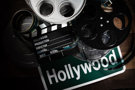 Multiple film reels and a clapboard on a wooden background. Film, Hollywood, entertainment industry objectsの写真素材