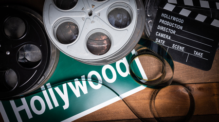 Multiple film reels and a clapboard on a wooden background. Film, Hollywood, entertainment industry objectsの写真素材