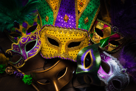 A group of carnivale or mardi gras mask with a yellow jester on a dark backgroundの写真素材