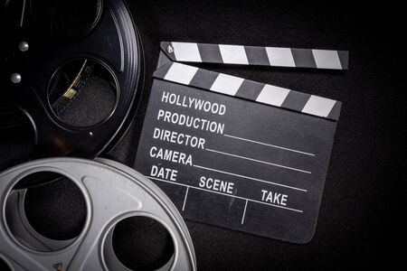 Multiple film reels and a clapboard on a wooden background. Film, Hollywood, entertainment industry objectsの写真素材
