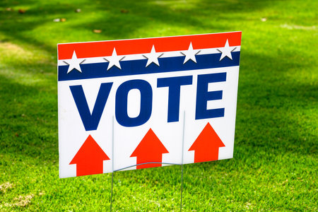 A VOTE sign at a polling place on green grassの写真素材