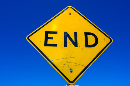 Yellow Road sign marking End of the Road in front of blue skyの写真素材