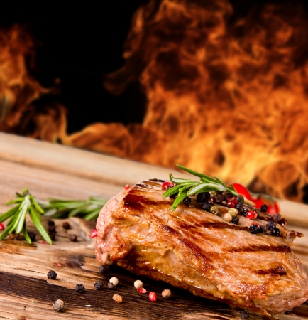 Grilled beef steak with flames on background の写真素材