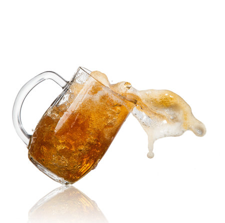 Beer splashing out of glass, isolated on white background