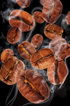 Flying coffee beans in smoke, isolated on black backgroundの写真素材