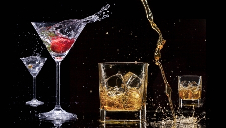 Alcohol drinks with splashes, isolated on black backgroundの写真素材
