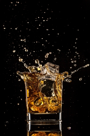  Glass of whiskey with splash, isolated on black backgroundの写真素材