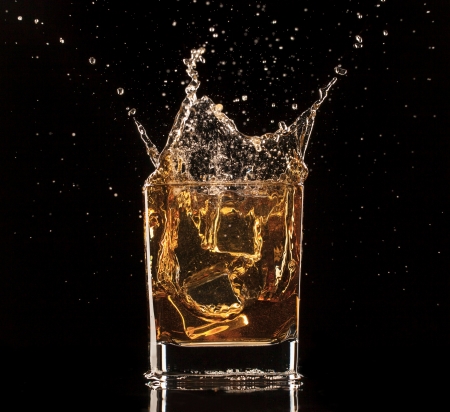 Isolated shot of whiskey with splash on black backgroundの写真素材