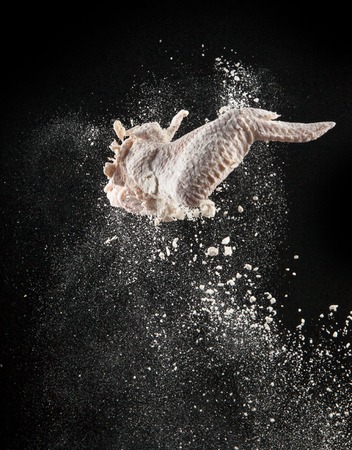 Flying raw chicken meat on blackの写真素材