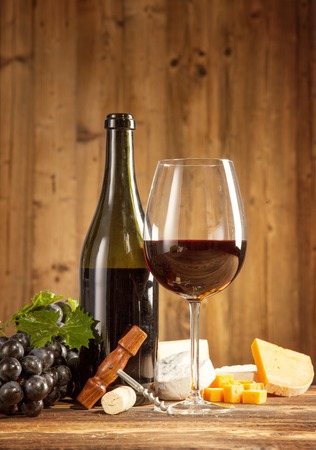 Wine with grapes and cheese on wooden planksの写真素材