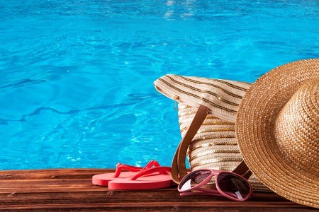 Concept of summer accessories on wood with blue water as backgroundの写真素材