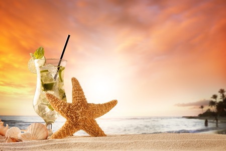 Summer concept with sandy beach, shells and mojito drinkの写真素材