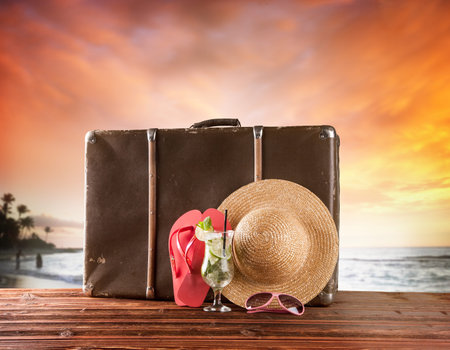 Concept of summer travelling with old suitcase and accessories  Blur beach on backgroundの写真素材