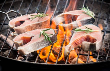 Delicious grilled salmon steaks on fireの写真素材