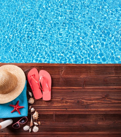 Concept of summer accessories on wood with blue water as backgroundの写真素材