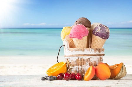 Set of various kind of fruit ice cream on wooden deck with blur sea on backgroundの写真素材