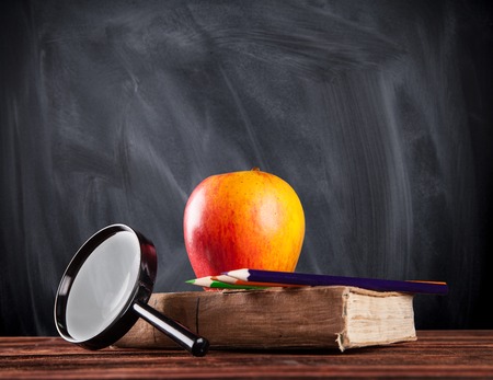 Still life of school tools and books with blackboard on backgroundの写真素材