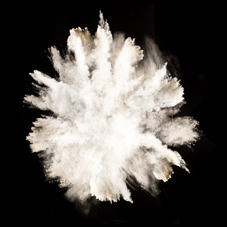 Freeze motion of white dust explosion isolated on black background