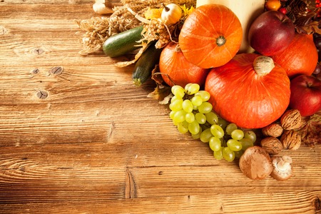 Autumn concept shot from top  Mix of pumpkins, fruit and vegetable on wooden table の写真素材
