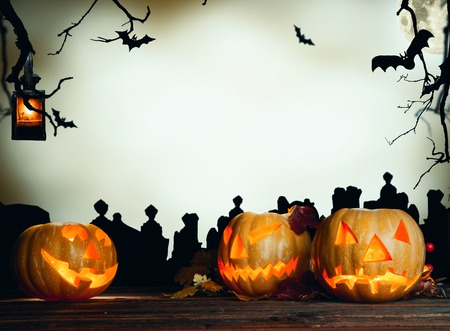 Concept of halloween pumpkin on wooden planks. Cemetery grave stones on backgroundの写真素材