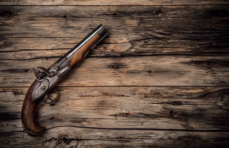 Very old hand gun on wooden planks, shot from upper viewの写真素材