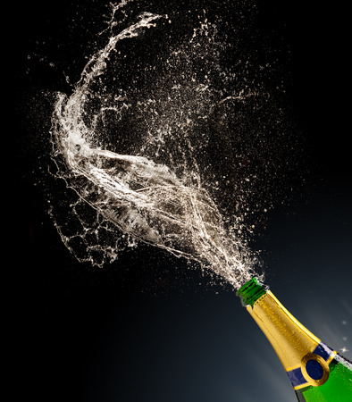Bottle of champagne with splash isolated on black backgroundの写真素材