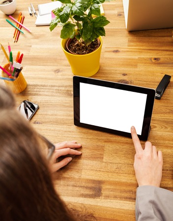 Woman working with tablet placed on wooden desk with blank space for textの写真素材