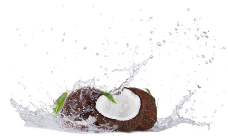Isolated shot of cracked coconuts with water splash on white backgroundの写真素材