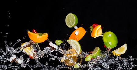 Mix of fruit with water splashes isolated on black backgroundの写真素材