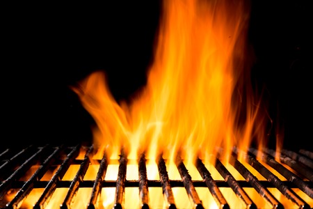 Empty grill grid with fire flames, isolated on black backgroundの写真素材