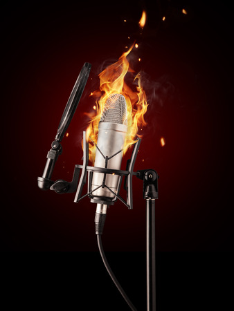 Professional singing microphone burning on black backgroundの写真素材